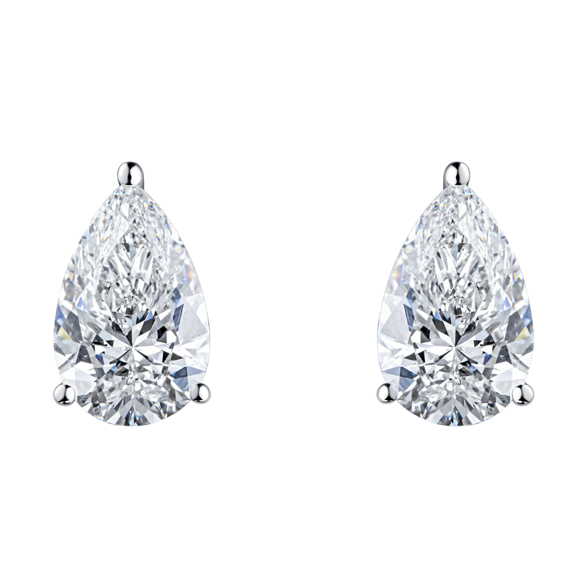 A pair of pear-cut diamond stud earrings in a three-prong silver setting, shown on a plain white background. #Metal_White Gold